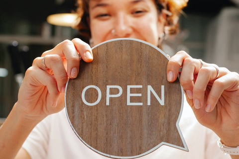 Student showing sign 'Open'